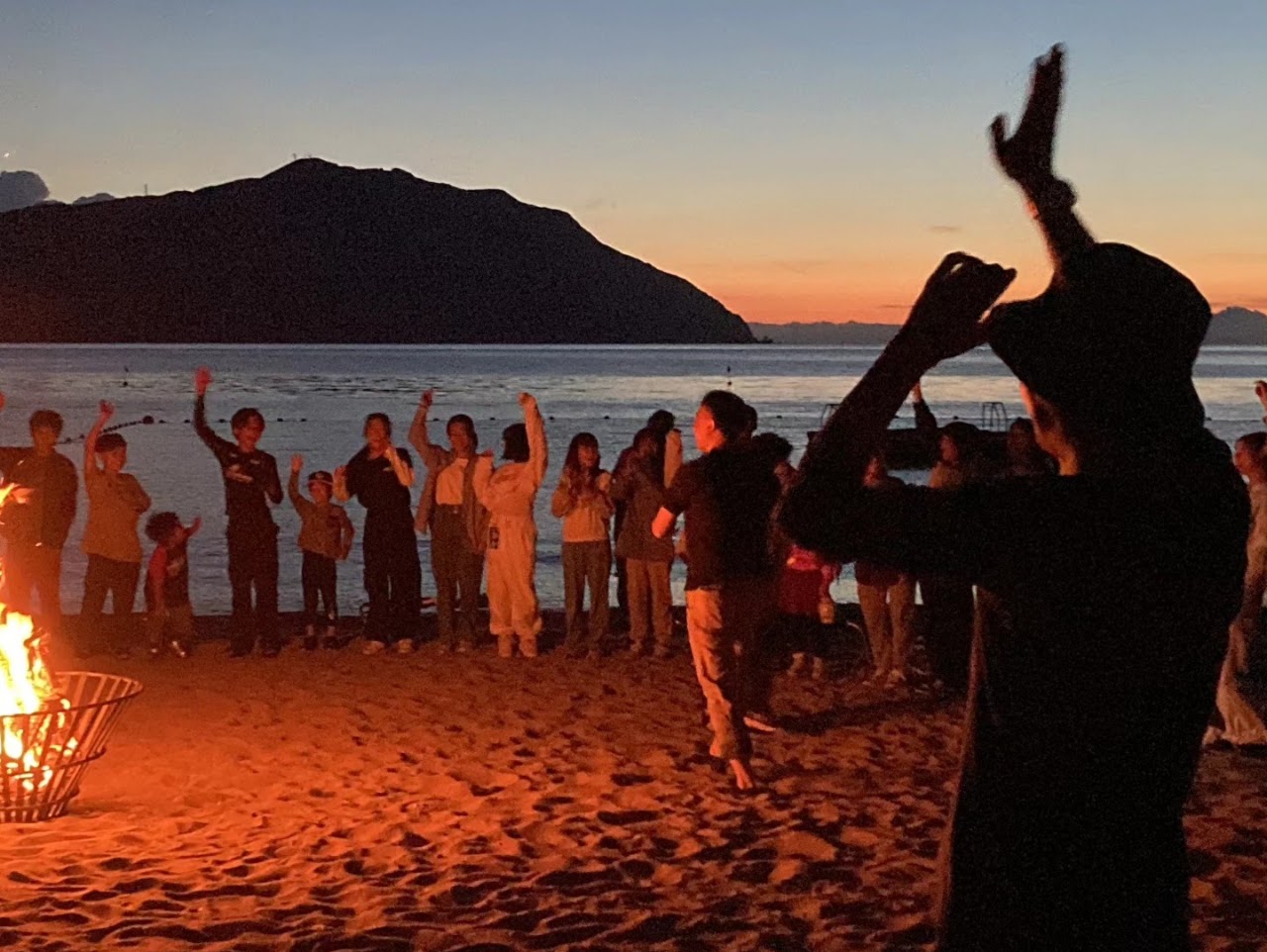 夕暮れの浜辺でのキャンプファイヤー